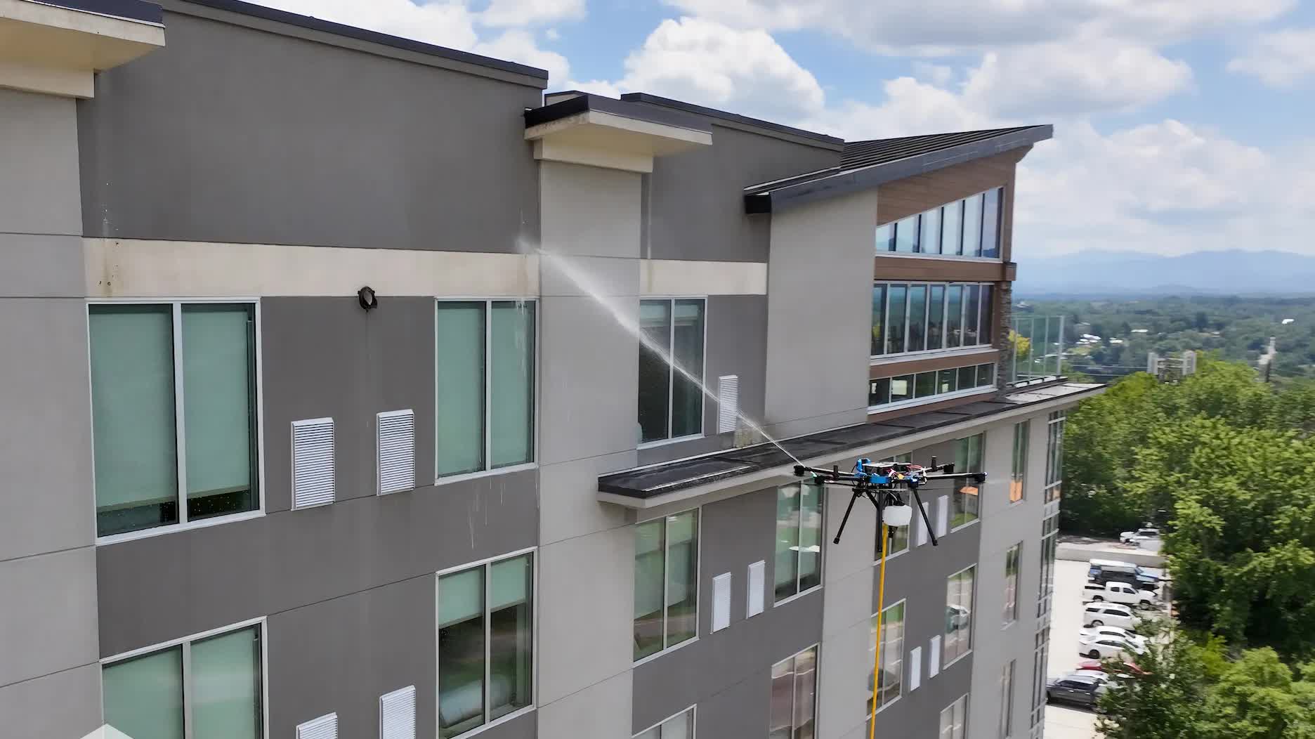 Drone-assisted window washing on a multi-story commercial building