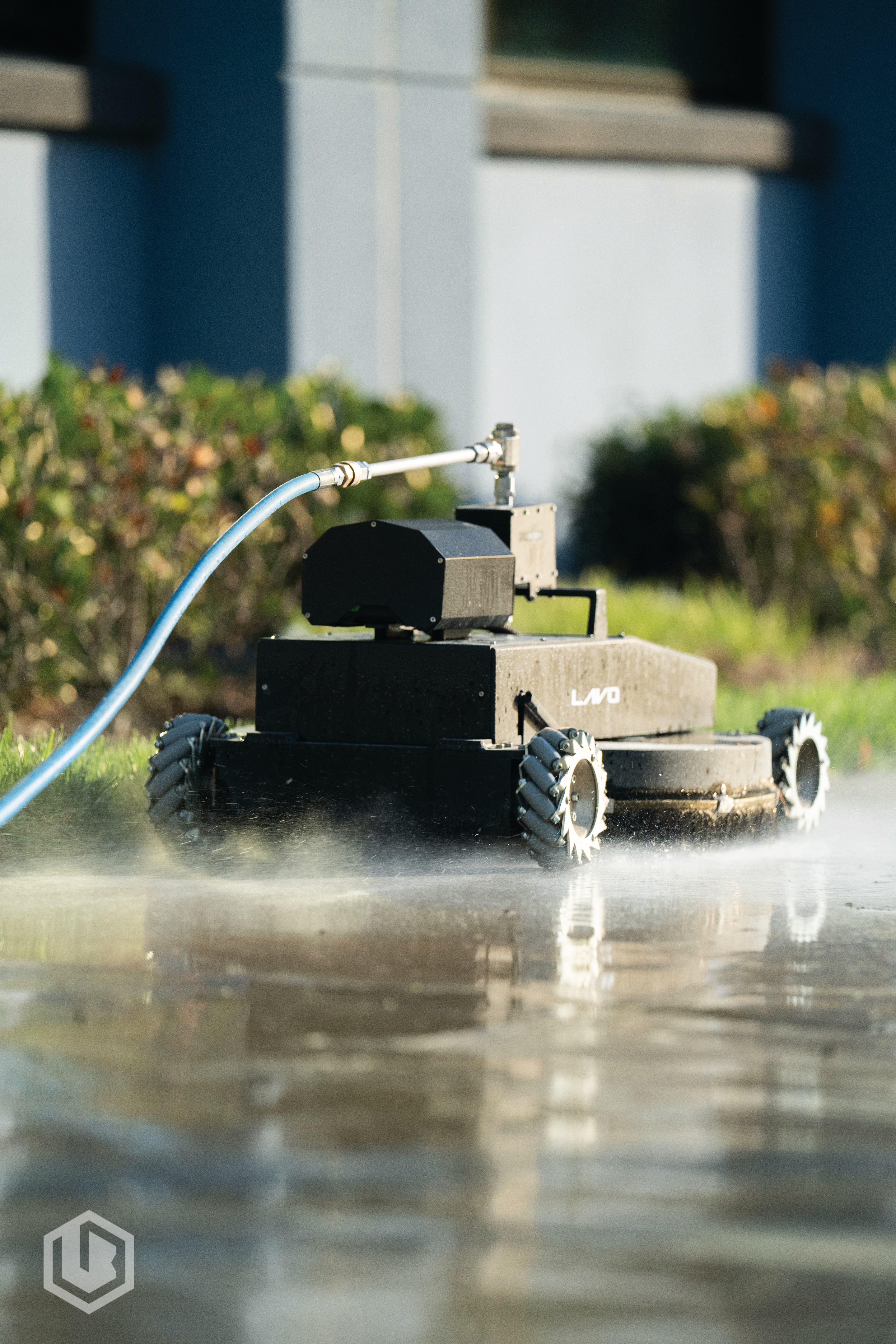 Lavo Bot robotic system power washing a commercial concrete parking lot
