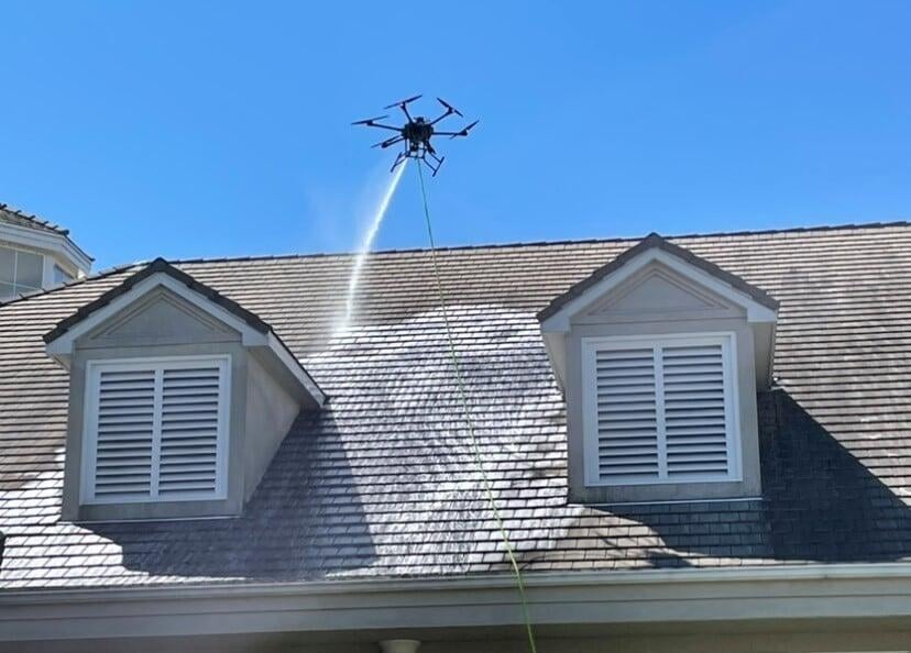 Low-pressure soft wash roof cleaning removing moss and algae from residential shingles